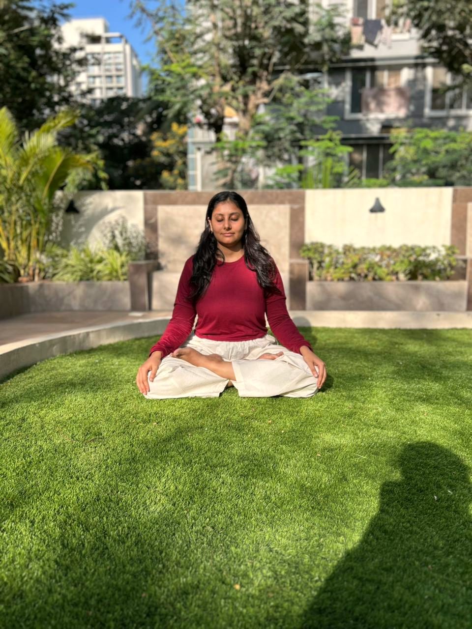 A student seated cross-legged in calm meditation